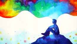 Person sitting on a hill, thinking in colour